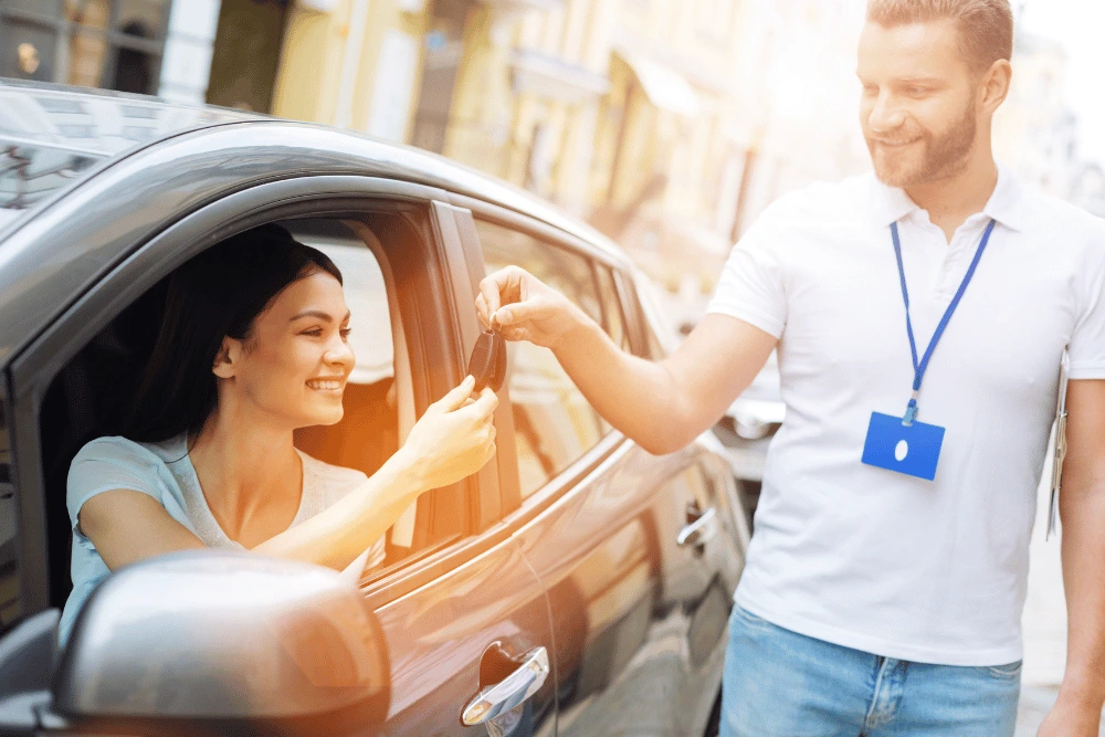 Asesor comercial entregando llaves de auto en renting a mujer